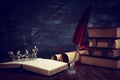 Low key image of beautiful queen/king crown, old books and feather quill ink pen over wooden table. fantasy medieval period Royalty Free Stock Photo