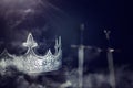 low key image of beautiful queen/king crown over antique book next to sword. fantasy medieval period. Selective focus. mist and Royalty Free Stock Photo