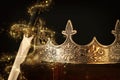 low key image of beautiful queen/king crown over antique box next to sword. fantasy medieval period. Selective focus. Glitter Royalty Free Stock Photo