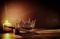 low key image of beautiful queen/king crown and sword. fantasy medieval period. Selective focus. Royalty Free Stock Photo