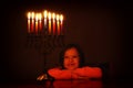 Low key image of jewish holiday Hanukkah background with cute girl looking at menorah & x28;traditional candelabra& x29; Royalty Free Stock Photo