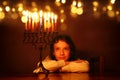 Low key image of jewish holiday Hanukkah background with cute girl looking at menorah & x28;traditional candelabra& x29; Royalty Free Stock Photo