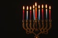 Low key Image of jewish holiday Hanukkah background with menorah & x28;traditional candelabra& x29; and burning candles. Royalty Free Stock Photo
