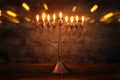Low key image of jewish holiday Hanukkah background with menorah & x28;traditional candelabra& x29; and burning candles Royalty Free Stock Photo