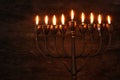 Low key image of jewish holiday Hanukkah background with menorah & x28;traditional candelabra& x29; and burning candles Royalty Free Stock Photo