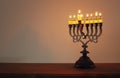 Low key image of jewish holiday Hanukkah background with menorah & x28;traditional candelabra& x29; and burning candles Royalty Free Stock Photo