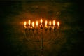 Low key image of jewish holiday Hanukkah background with menorah & x28;traditional candelabra& x29; and burning candles Royalty Free Stock Photo