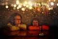 Low key image of jewish holiday Hanukkah background with two cute kids looking at menorah Royalty Free Stock Photo