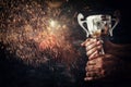 low key image of a man holding a trophy cup over dark background Royalty Free Stock Photo