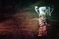 low key image of a man holding a trophy cup over dark background Royalty Free Stock Photo