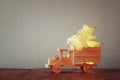 Low key image of retro wooden toy car with garland golden stars over wooden table. nostalgia and simplicity concept Royalty Free Stock Photo