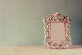 Low key image of vintage antique classical frame on wooden table. filtered image