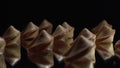 Low key light. A lot of Chinese cookies rotate on a black background. Traditional fortune cookie. Nice view on spinning