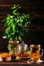 Low key photo of hot herbal tea with sea buckthorn and mint