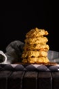 Low key photo of stack of of ginger, lemon and apple biscuits on wooden table.