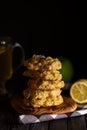 Low key photo of stack of of ginger, lemon and apple biscuits on wooden table.