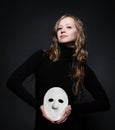 Low key portrait of a beautiful woman holding mask Royalty Free Stock Photo