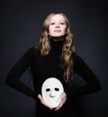 Low key portrait of a beautiful woman holding mask Royalty Free Stock Photo