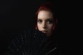 Low key portrait of beautiful young woman with fan Royalty Free Stock Photo