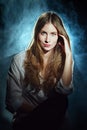 Portrait in mist of dreamy girl in white shirt and jeans with long curly hair Royalty Free Stock Photo