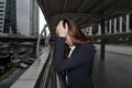 Low key portrait of stressed frustrated young Asian business woman touching head with hands and feeling tired or disappointment at