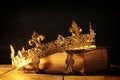 low key of queen/king crown on old book. vintage filtered. fantasy medieval period