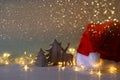 Low key of wooden christmas tree and deer next to santa hat Royalty Free Stock Photo