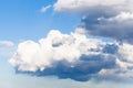 Low large white rainy clouds in blue sky