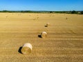 Low level aspect view over a wheat field with bales of straw ready for collection Royalty Free Stock Photo