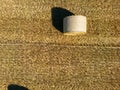 Low level top down birds eye view aspect view over a wheat field with bales of straw ready for collection Royalty Free Stock Photo