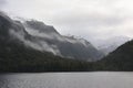 Low lying clouds across the mountains at Lake Manapouri in New Zealand