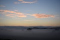 low morning fog with blue sky and glowing clouds Royalty Free Stock Photo