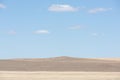 Low mountains in the steppe, blue sky and clouds Royalty Free Stock Photo