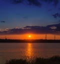 Orange sunset over river and city on horizon Royalty Free Stock Photo