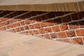 Low parapet made of raised red and dark red bricks beside brick