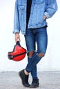 Portrait of motorcyclist with ripped jeans holding helmet
