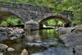 Low Creek on a Rocky Path Under the Arch of an Old Stone Bridge Royalty Free Stock Photo