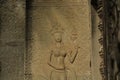 A low-relief sandstone carving of Apsara smiling and teeth at the wall of Angkor Wat in Siem Reap