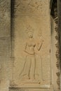 A low-relief sandstone carving of Apsara smiling and teeth at the wall of Angkor Wat in Siem Reap