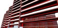 Low-rise apartment building. Long modern balconies fenced with glass. Red day illumination catches the client\'s eye.