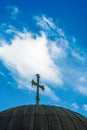 Low-rise day sunny view of Christian Orthodox Church rooftop cross against blue sky with clouds Royalty Free Stock Photo