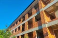 Low-rise house under construction with use of red hollow heat-retaining bricks with partial monolithic structure of