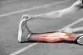 Low section of athlete stretching on sports track