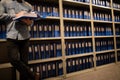 Low section of businessman reading file in storage room Royalty Free Stock Photo