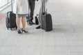 Low section of businesspeople with luggage standing on railroad platform