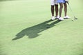 Low section of couple playing golf at course