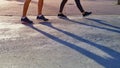 low section of couple`s legs in sport shoes are warming up by walking before exercise