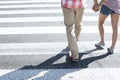 Low section of couple walking on crosswalk