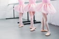 low section of cute little kids in pink tutu skirts and ballet shoes dancing in studio