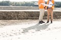 Low section of engineers with blueprints standing at construction site Royalty Free Stock Photo